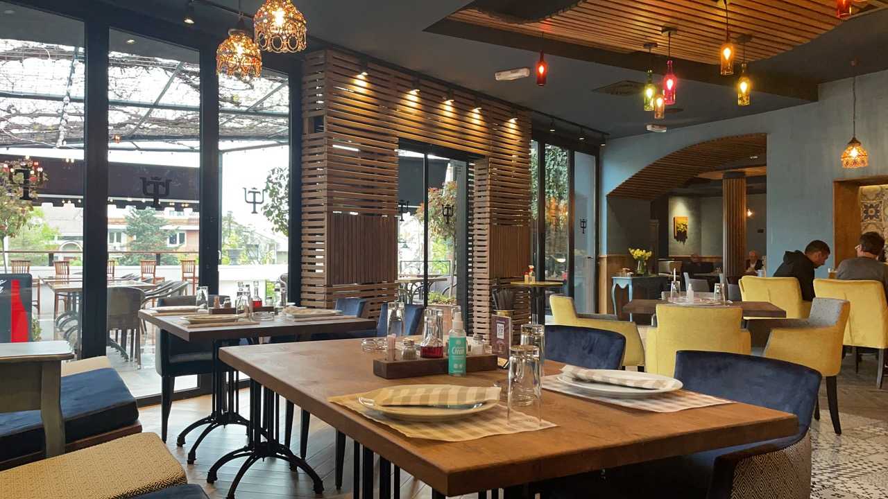 Svetla unutrašnjost restorana sa brojnim specijalno izrađenim elementima od drveta